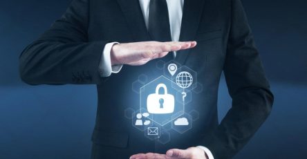 Businessman in suit holding a digital padlock shield representing cybersecurity protection for UAE companies