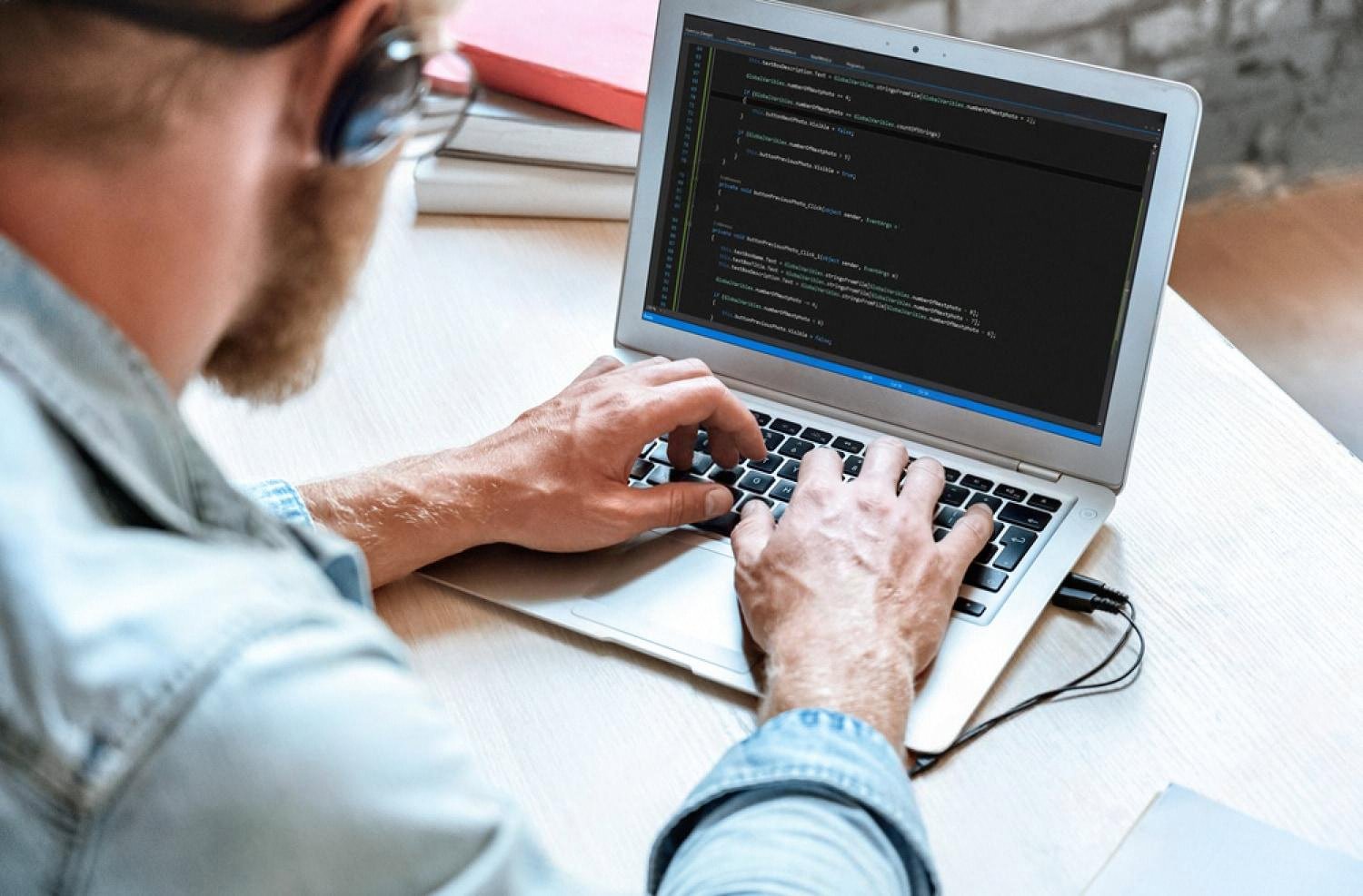 Developer reviewing source code on a laptop to check for security vulnerabilities