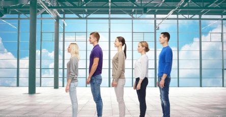 People standing in a single-file line inside a bright modern hall, illustrating the old queue system at UAE visa centers